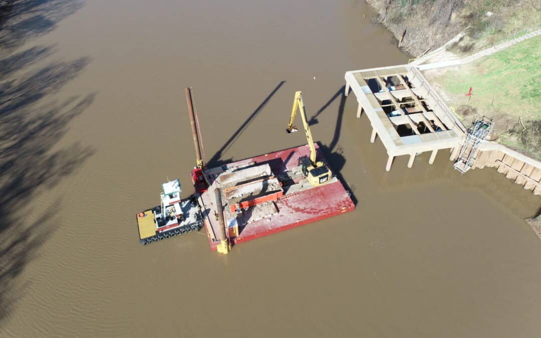 EXCAVATOR PLACES RIPRAP IN BRAZOS